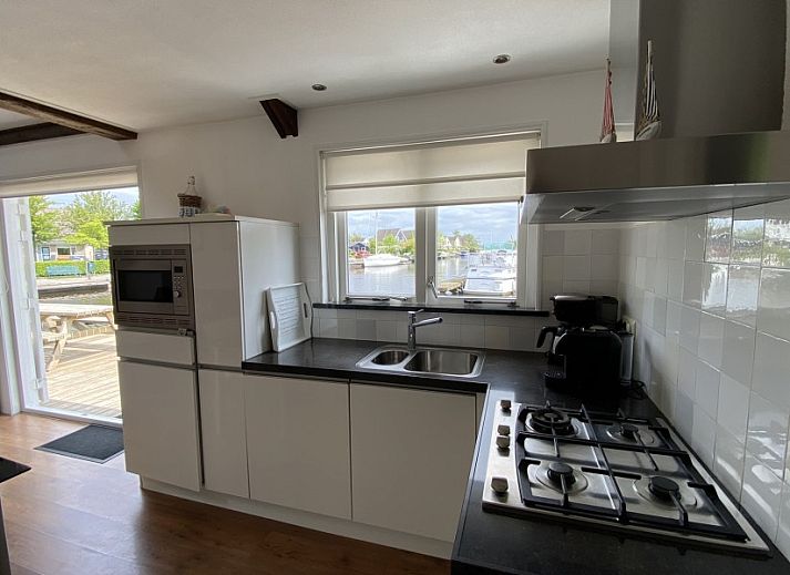 Vor dem Havenhuisje in Terherne, Ferienhaus am Sneekermeer mit sonniger Terrasse und gemuetlichen Sitzgelegenheiten.