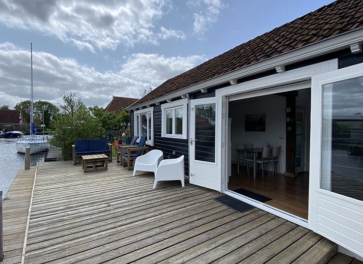 Gemuetliches Wohnzimmer des Havenhuisje, Ferienhaus in Terherne, mit hohen Decken und gemuetlicher Einrichtung am Sneekermeer.