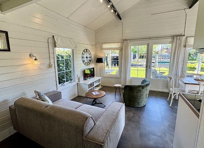 Entspannen Sie sich auf der Terrasse des Ferienhauses De Koumelker in Terherne, Sneekermeer. Geniessen Sie die ruhigen friesischen Seen und die gruene Umgebung.