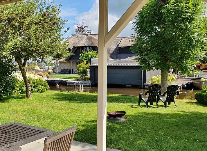 Entspannen Sie sich auf der Terrasse des Ferienhauses De Koumelker in Terherne, Sneekermeer. Geniessen Sie die ruhigen friesischen Seen und die gruene Umgebung.