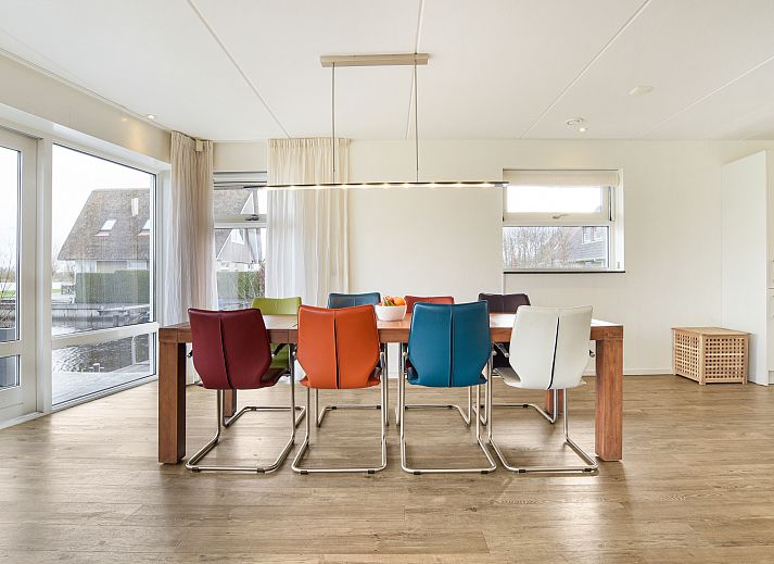 Heller Essbereich im Wasserpark Terherne, 8-Personen-Wasserhaus, Terherne, Sneekermeer, mit bunten Stuehlen.