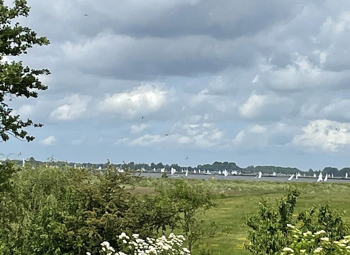 Cozy dining area in Bungalow Sneekermeer, Goingarijp. Vacation home with modern furnishings and garden views near Frisian lakes.