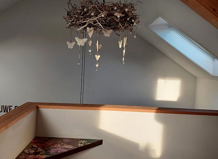 Uniek interieurontwerp in Vakantiehuisje in Uitwellingerga met opvallende rode accenten en open planken.