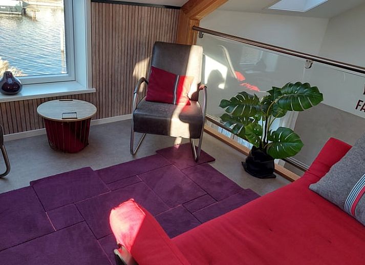 Uniek interieurontwerp in Vakantiehuisje in Uitwellingerga met opvallende rode accenten en open planken.