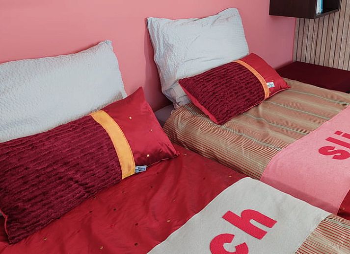 Uniek interieurontwerp in Vakantiehuisje in Uitwellingerga met opvallende rode accenten en open planken.