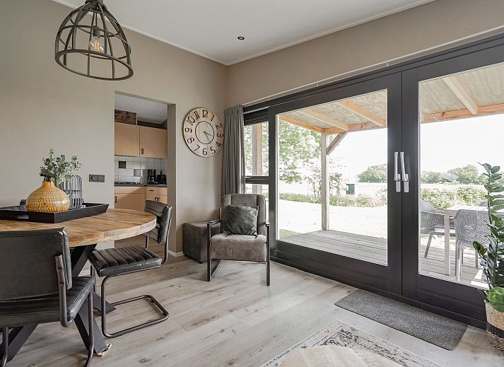 Bungalow de Optimist in Offingawier biedt een charmant terras met houten overkapping en uitzicht op de Friese meren.