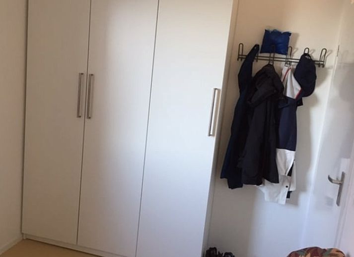 Gemuetliche Terrasse am Ferienhaus in Offingawier, mit bequemer Sitzecke und Sonnenschirm.