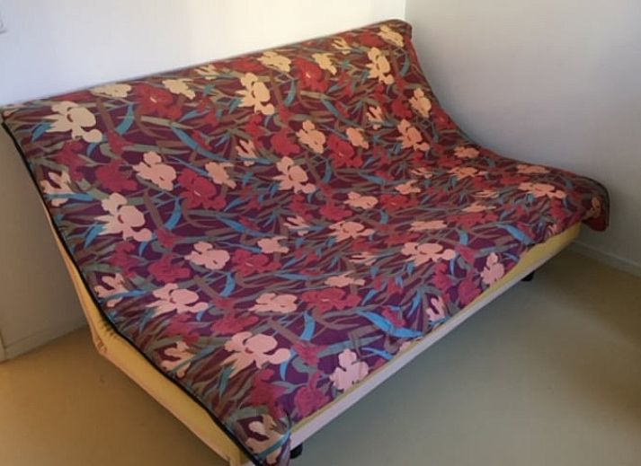 Gemuetliche Terrasse am Ferienhaus in Offingawier, mit bequemer Sitzecke und Sonnenschirm.