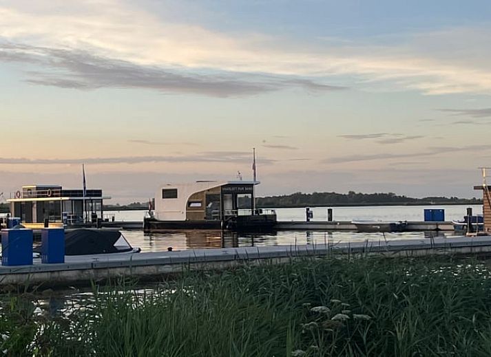 Drijvende vakantiewoning Vakantiehuis in Offingawier, gelegen aan de kade van het Sneekermeer.