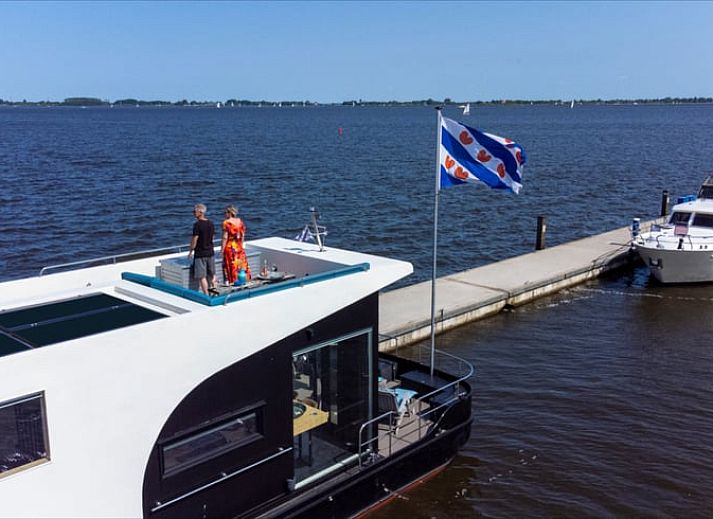 Uitzicht vanaf het dakterras van Vakantiehuis in Offingawier op het Sneekermeer met Friese vlag.