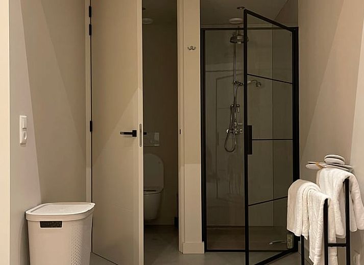 Gezellige binnenruimte van Huisje in Sumar in Bergumermeer, Friese meren, met houten eettafel en hanglampen.