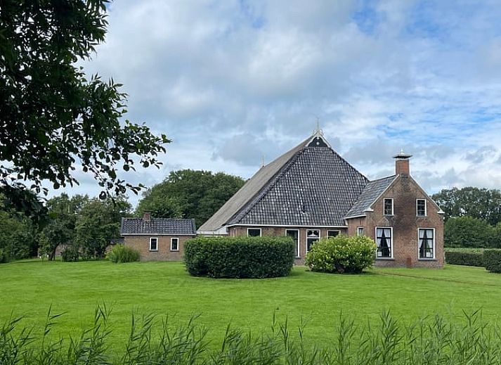 Gezellige binnenruimte van Huisje in Sumar in Bergumermeer, Friese meren, met houten eettafel en hanglampen.