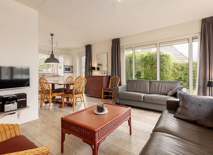 Spacious living room of Wetterbungalow 6 in Earnewald, Frisian Lakes, with comfortable seating area and views of the green surroundings.