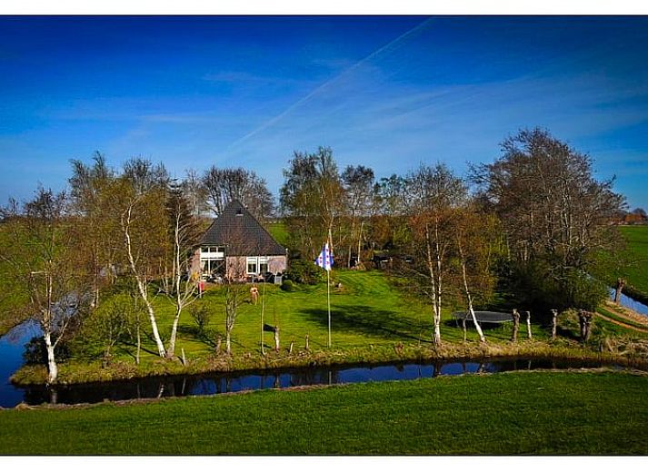 Luftaufnahme von Cottage in De Veenhoop, Ferienhaus umgeben von gruenen Feldern in Princehof, Friesische Seen.
