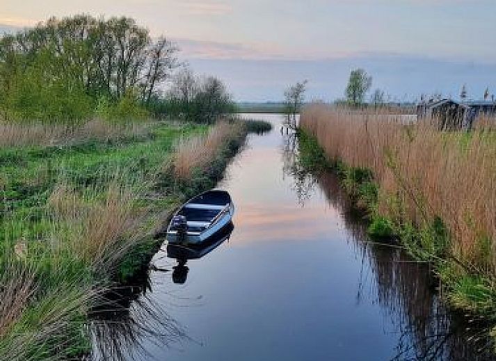 Vakantiehuis Natuurlijk de Veenhoop in De Veenhoop met houten veranda en groene omgeving.