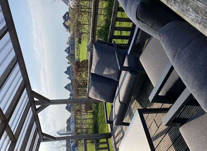 Vakantiehuis 4-persoons Doutzen in De Veenhoop, omringd door groene heggen en blauwe lucht.