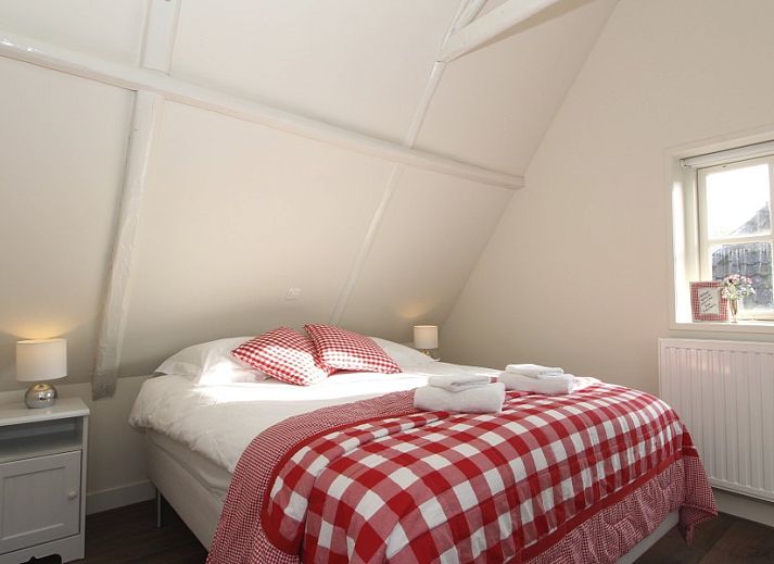 De Thuiskamer, een charmant vakantiehuis in Grou, Friesland, met kleurrijke bloemen en authentieke Friese architectuur op het platteland.