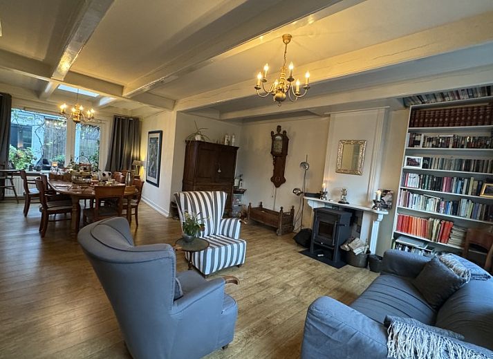 De Thuiskamer, een charmant vakantiehuis in Grou, Friesland, met kleurrijke bloemen en authentieke Friese architectuur op het platteland.