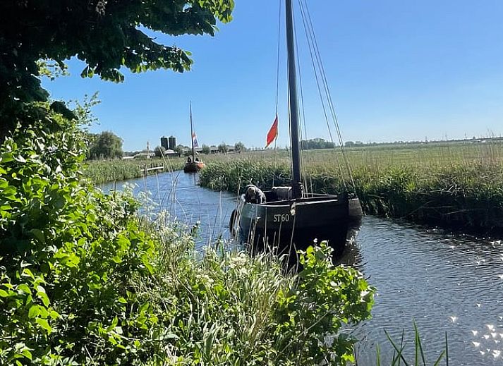 Stijlvolle eetkamer in Vakantiehuis in Grou, Grouw, met vintage kast en klok, nabij Pikmeer.