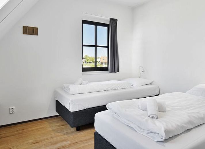 Stijlvolle woonkamer in Esonstad vakantiehuis, Anjum, met wijn en glazen op tafel.
