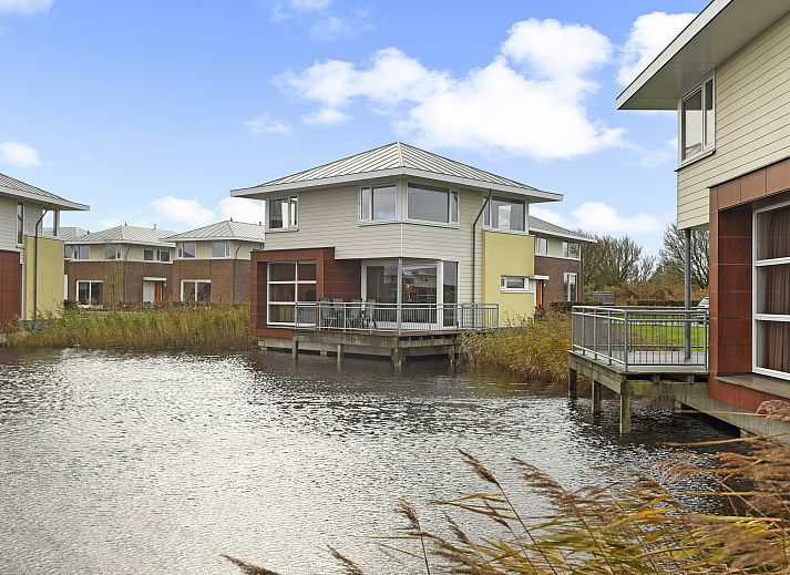 Lichte woonkamer van Esonstad 6-persoons woning in Anjum, Lauwersmeer met uitzicht op het water en moderne inrichting.