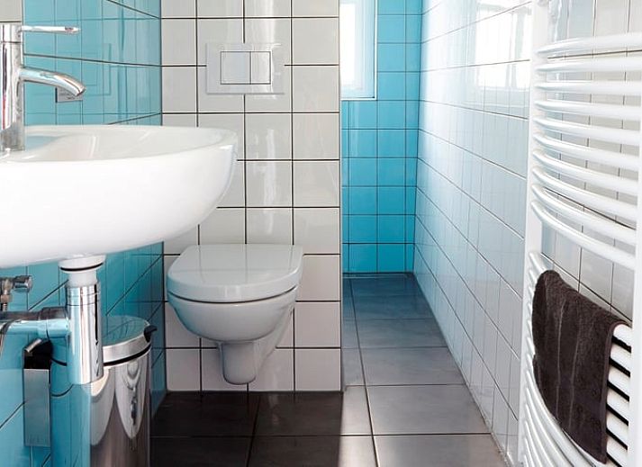 Cozy living room in Holiday Home in Kollumerpomp, Lauwersmeer, with fireplace and comfortable seating area for relaxation.