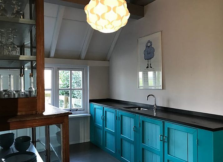 Cozy living room in Holiday Home in Kollumerpomp, Lauwersmeer, with fireplace and comfortable seating area for relaxation.