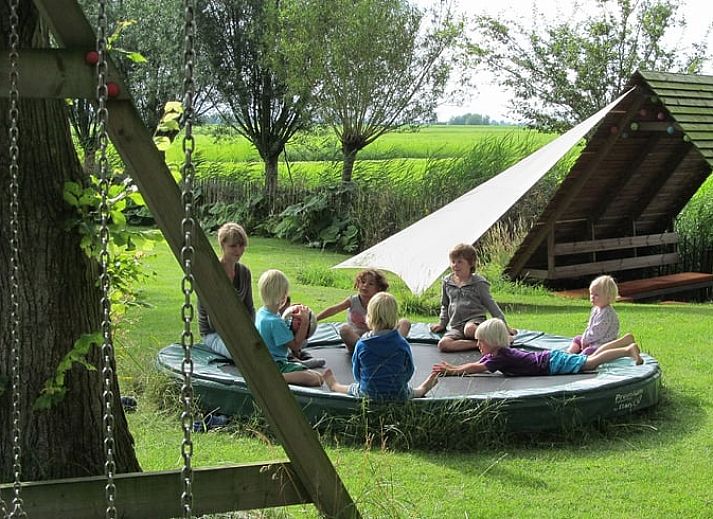 Spacious dining room in Holiday home in Kollumerpomp, Lauwersmeer, with large wooden table and lots of natural light.