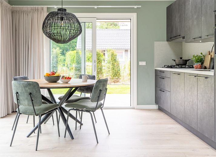 Buitenzijde van De N8UIL vakantiehuis in Spier, Midden Drenthe, met zonnig terras en groene tuin.