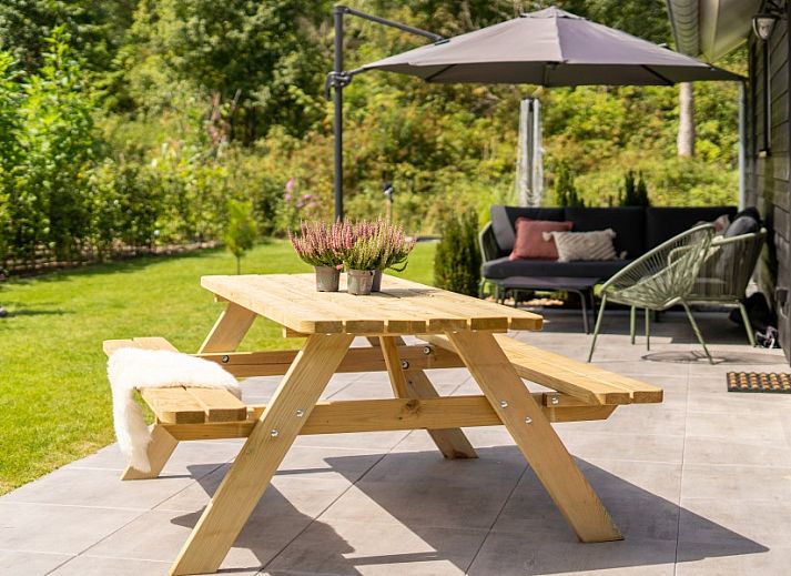 Buitenzijde van De N8UIL vakantiehuis in Spier, Midden Drenthe, met zonnig terras en groene tuin.