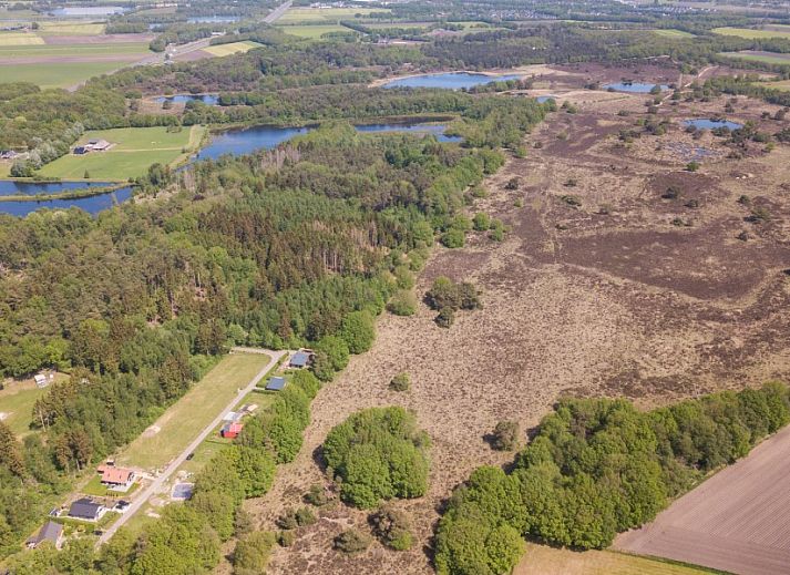 Buitenzijde van De N8UIL vakantiehuis in Spier, Midden Drenthe, met zonnig terras en groene tuin.