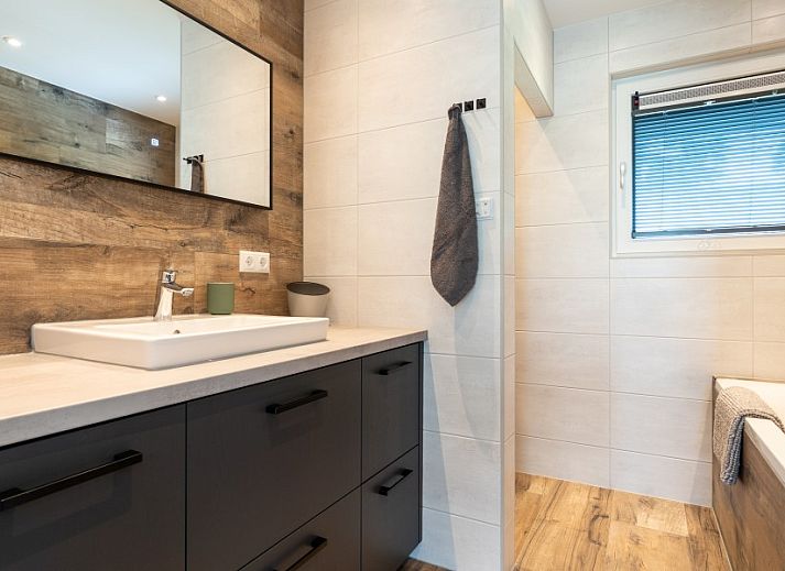 Buitenzijde van De N8UIL vakantiehuis in Spier, Midden Drenthe, met zonnig terras en groene tuin.