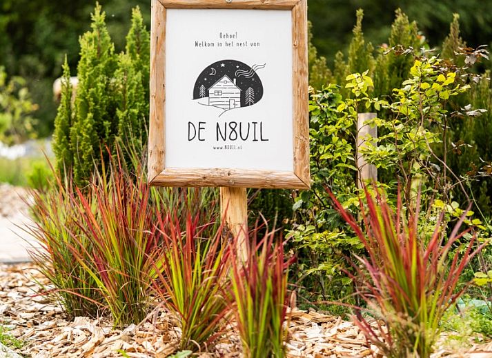 Veranda van De N8UIL vakantiehuis in Spier, Midden Drenthe, met comfortabele zitplaatsen en uitzicht op de tuin.