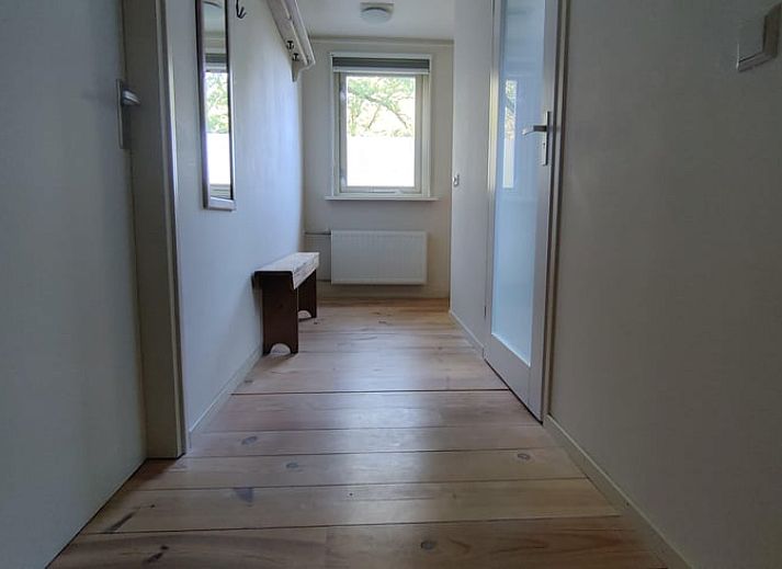 Lichte woonkamer van Vakantiehuis in Spier met uitzicht op de groene omgeving van Drenthe.