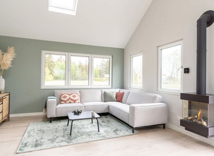 Vakantiehuisje in Spier, Drenthe, omringd door groene tuin en blauwe lucht.