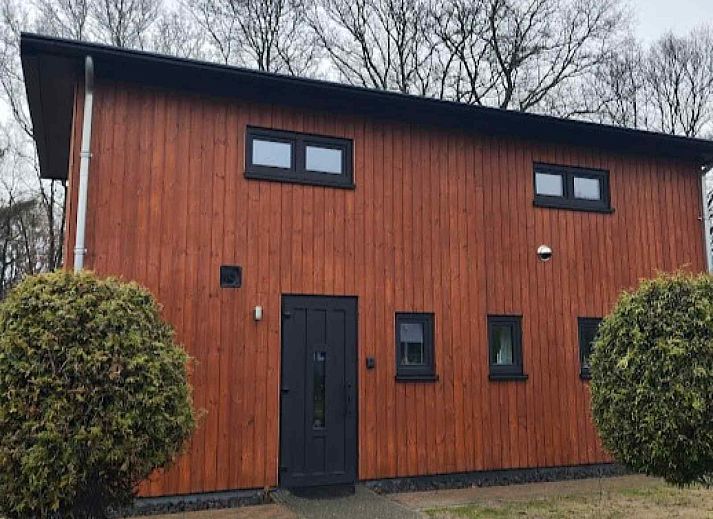 DG1552 Ferienhaus in Spier, Drenthe, umgeben von verschneiten Baeumen und natuerlicher Umgebung.