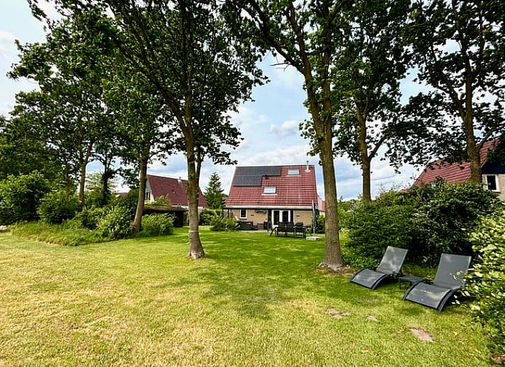 Ontspan op de veranda van Vakantiehuisje in Schoonloo, Midden Drenthe, met comfortabel terrasmeubilair en uitzicht op de groene natuur.