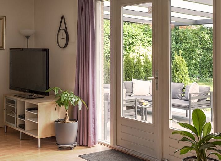 Ontspan op de veranda van Vakantiehuisje in Schoonloo, Midden Drenthe, met comfortabel terrasmeubilair en uitzicht op de groene natuur.