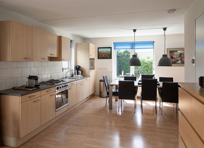 Ontspan op de veranda van Vakantiehuisje in Schoonloo, Midden Drenthe, met comfortabel terrasmeubilair en uitzicht op de groene natuur.