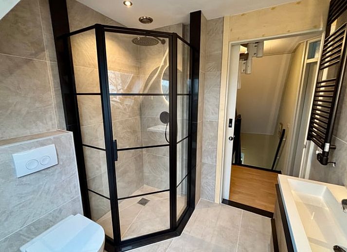 Gezellige woonkamer in Vakantiehuisje in Schoonloo, Drenthe met comfortabele zithoek en natuurlijk licht, ideaal voor een ontspannen verblijf.