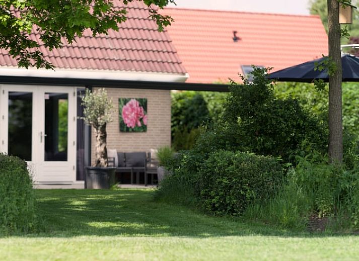 Gezellige woonkamer in Vakantiehuisje in Schoonloo, Drenthe met comfortabele zithoek en natuurlijk licht, ideaal voor een ontspannen verblijf.