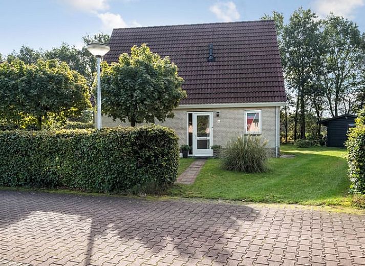 Gezellige slaapkamer in Vakantiehuisje in Schoonloo, Midden Drenthe met uitzicht op groene natuur door het raam.
