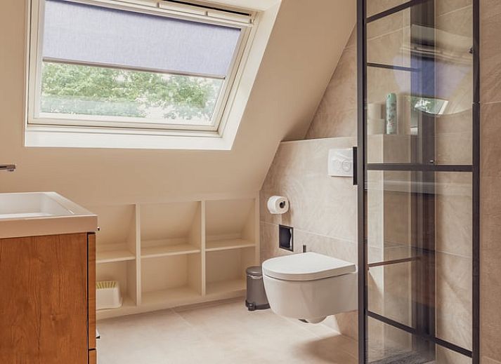 Gezellige slaapkamer in Vakantiehuisje in Schoonloo, Midden Drenthe met uitzicht op groene natuur door het raam.