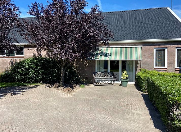 Ferienhaus in Beilen, Zentral-Drenthe, mit gemuetlichem Vorgarten und Bank zum Entspannen.