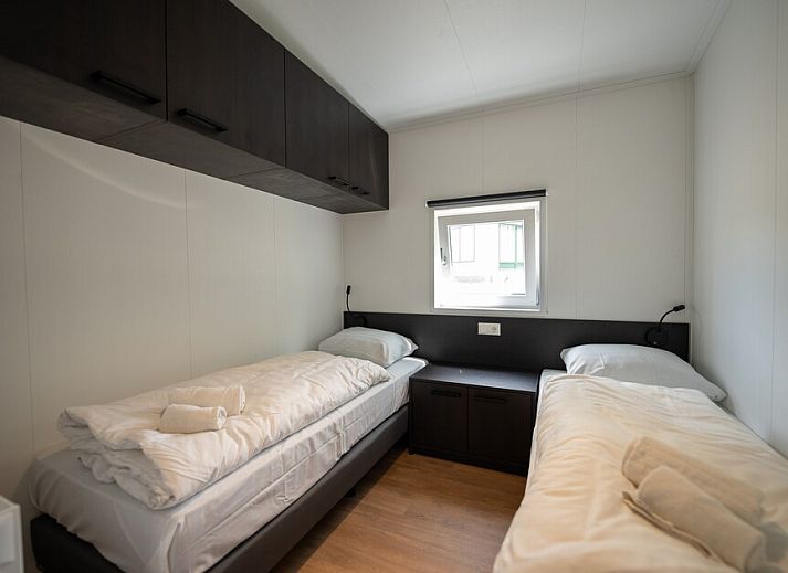 Gemuetliches Wohnzimmer des Chalets Forest 4 in Gasselternijveen, Zentral-Drenthe, mit bequemer Sitzecke und moderner Kueche.