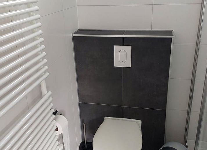 Cozy living room in Holiday Home in Gasselte, Drenthe, with comfortable sofa and view of green garden.