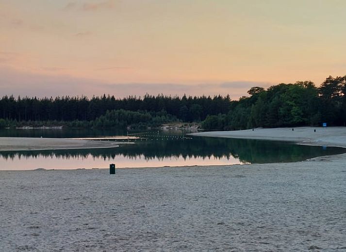 Cozy living room in Holiday Home in Gasselte, Drenthe, with comfortable sofa and view of green garden.