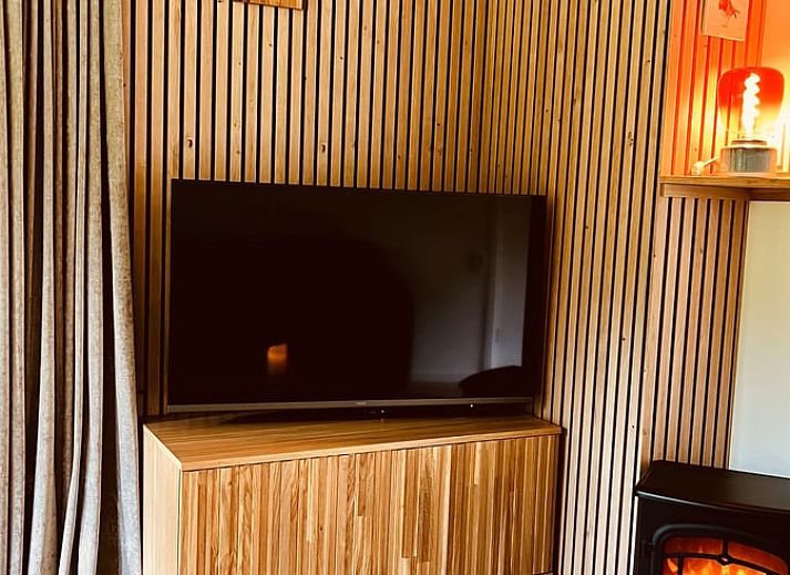 Gezellige veranda van Huisje in Gasselte, vakantiehuis in Midden Drenthe, met comfortabele zithoek en uitzicht op kleurrijke hortensia's.