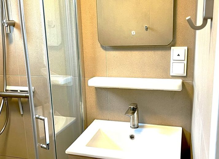 Gezellige veranda van Huisje in Gasselte, vakantiehuis in Midden Drenthe, met comfortabele zithoek en houten afwerking voor ontspanning.