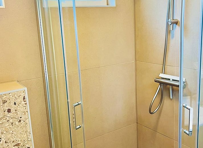 Gezellige veranda van Huisje in Gasselte, vakantiehuis in Midden Drenthe, met comfortabele zithoek en houten afwerking voor ontspanning.